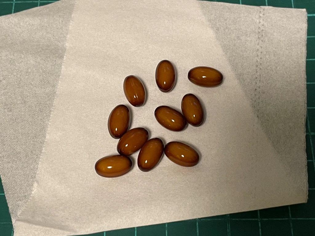 シードコムス大豆イソフラボンアグリコン。オリーブオイルでコーティングされた茶色い粒状サプリ